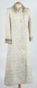 A padded cream silk and beaded frock coat:.