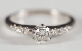 An 18ct white gold and diamond ring:, the central, circular, brilliant-cut diamond approximately 0.