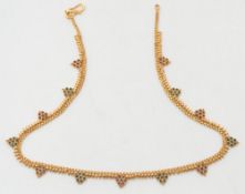 An Indian enamelled gold necklace:, the mesh-link necklace with red and green enamelled motifs.