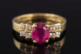 A modern ruby and diamond ring: with central oval ruby approximately 7.8mm x 6.