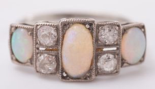 An 18ct white gold, opal and diamond seven stone ring:, with graduated opals between circular,