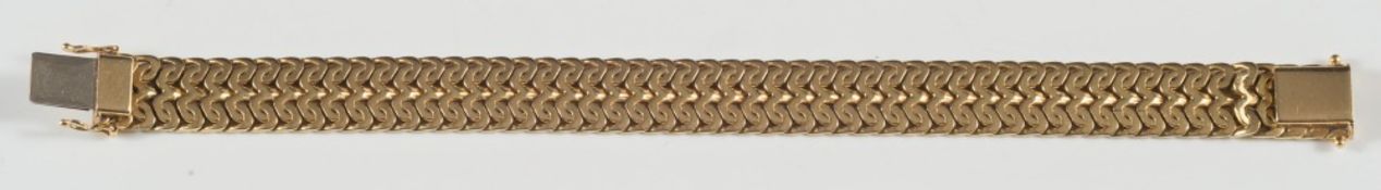 A yellow coloured bracelet of integral design:, stamped '750', approximately 45gms gross weight.
