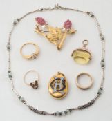 An oval enamelled initial, yellow metal locket, a ruby-set brooch: of foliage design stamped '750',