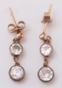 A pair of diamond two stone drop earrings: each with a circular,