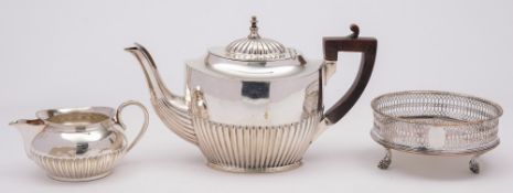 A silver plated teapot: with half reeded decoration, a plated cream jug and coaster.