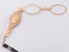 A gold pierced lorgnette: on black moire strap, 38gms gross weight.