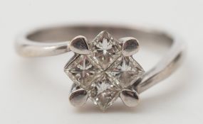 A diamond mounted four-stone cluster ring: with invisibly-set princess-cut stones on a cross over