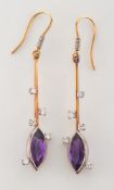 A pair of amethyst and diamond pendant earrings: each with a navette-shaped amethyst drop,