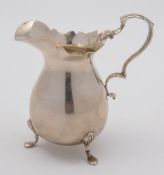 An Edward VII silver cream jug, makers marks worn, Birmingham, 1903:, of plain ovoid form,