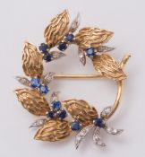 An 18ct gold,sapphire and diamond floral circular brooch:, approximately 12gms gross weight.