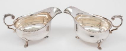 A pair of plated sauce boats: of traditional design, with beaded border, raised on three swept feet.