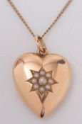 A Victorian gold heart-shaped pendant with central seed pearl cluster:,