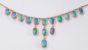 A black opal fringe necklace: with fifteen oval opals, on 9ct gold fine link chain.