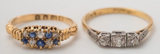 An 18ct gold and diamond three stone ring and a gold, sapphire and diamond ten stone cluster ring:.
