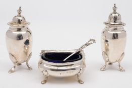 A pair of silver pepperettes: and a silver shaped oval salt with blue glass liner various makers