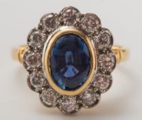 An 18ct gold, sapphire and diamond oval cluster ring:,