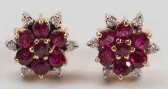 A pair of ruby and diamond circular cluster ear-studs with butterfly scrolls stamped '585':.