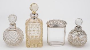 Three clear glass and silver mounted scent bottles: together with a silver mounted jar,