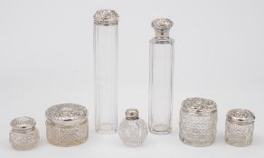 A collection of silver mounted and clear glass mounted dressing table jars: rouge pots, etc,