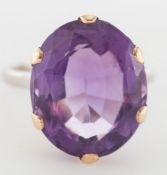 An oval amethyst single-stone dress ring:.