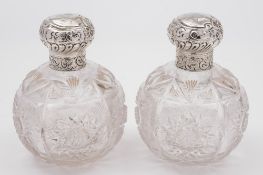 A pair of clear glass and silver mounted scent bottles: monogrammed, 14cm. high..