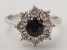 An 18ct white gold, sapphire and diamond circular cluster ring:, the central,