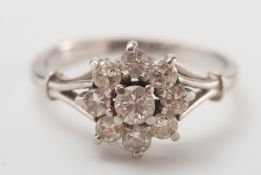 A diamond circular cluster ring: of floral design with circular,