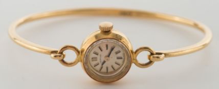 Certina. A lady's 18ct gold bangle wristwatch:, the circular satin-finish dial with baton markers.