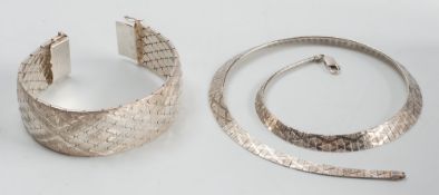 A silver flexible wide bracelet and a necklace:.