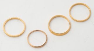 A 22ct gold band of textured design, two other 22ct gold bands and a plain band:.