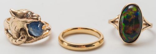 A blue star sapphire ring stamped '750', an 18ct gold wedding band and an oval gem-set ring:.