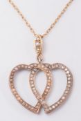 A seed pearl mounted and rose diamond mounted double heart pendant on chain:.