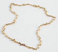 An 18ct gold necklace of beaded rod-like linking:.