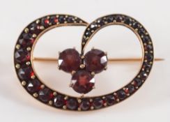 A gold and garnet set brooch: with trefoil garnet cluster within a surround of graduated garnets.