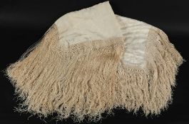 An ivory coloured shawl with raised floral embroidered decoration,