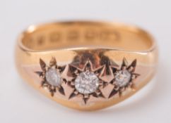 A 22ct gold and diamond star-set, three stone ring:.