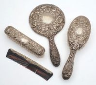 A four piece silver backed dressing table set: includes two brushes, comb and mirror.