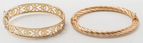 A 9ct gold hinged bangle of pierced design and a gold rope-twist design bangle:.