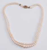 A graduated cultured pearl two-string necklace: with 9ct gold and gem-set oval clasp.