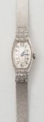 A lady's platinum and diamond oval wristwatch:, the dial with Arabic numerals,