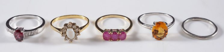 A platinum band, an opal and gem set ring, a pink gem set three stone ring and two modern rings:.