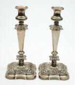 A pair of silver plated candlesticks: with urn shaped nozzles,