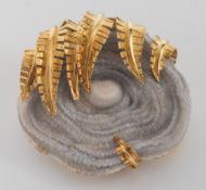 An 18ct gold and agate round brooch: with natural agate nodule secured by a fringe of gold fern