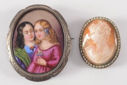 A porcelain panel brooch depicting two young girls and an oval shell cameo brooch:.