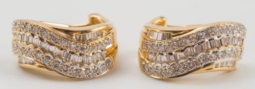 A pair of diamond mounted ear-clips: of wavy three-row clusters,