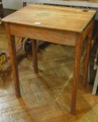An oak school desk with inkwell and lift