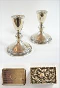 A pair of white metal dwarf candlesticks