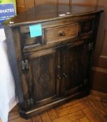 A reproduction stained oak corner cupboa