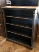 An oak open bookcase of four shelves rai