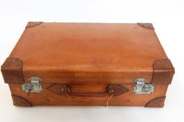A hide suitcase with reinforced corners and chrome mounts, initialled 